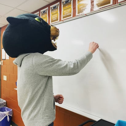 Reedsville panther standing at whiteboard